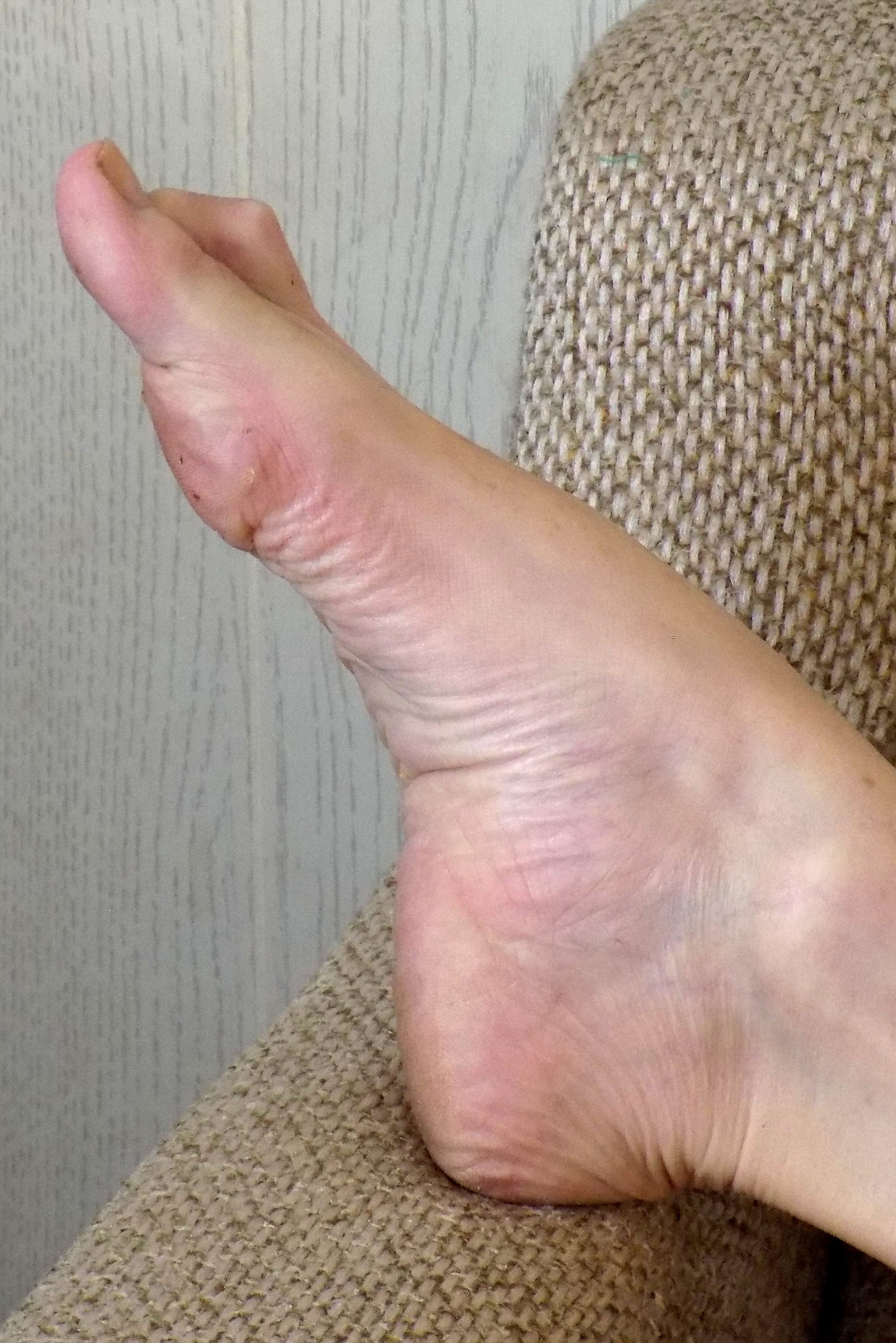 My sexy right foot posed extended resting on the arm of the couch